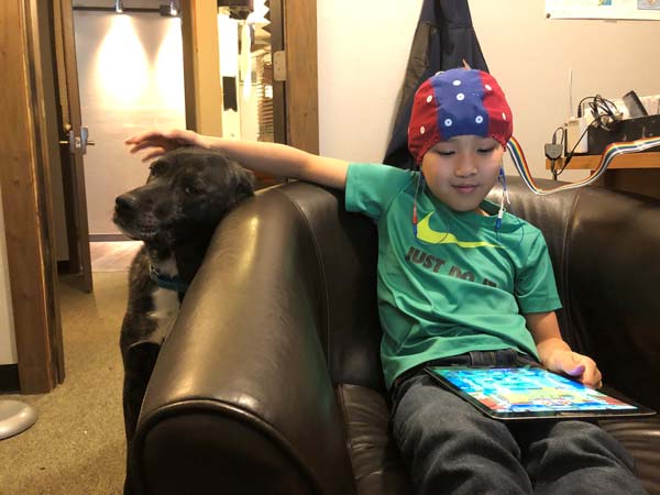 Preteen boy with dog on the couch