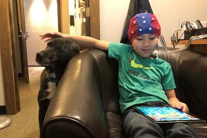 Preteen boy undergoing neurofeedback with his canine